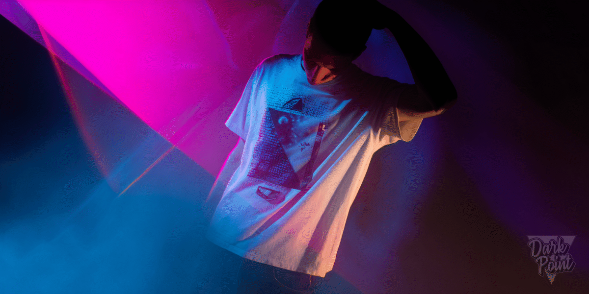Person in a limited edition graphic tee under moody neon lighting, symbolizing exclusive merch and underground culture